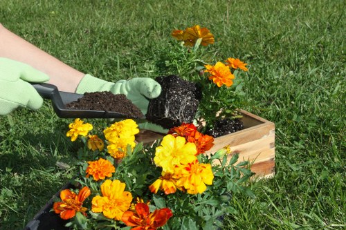 Operative wearing PPE while using a hedge trimmer